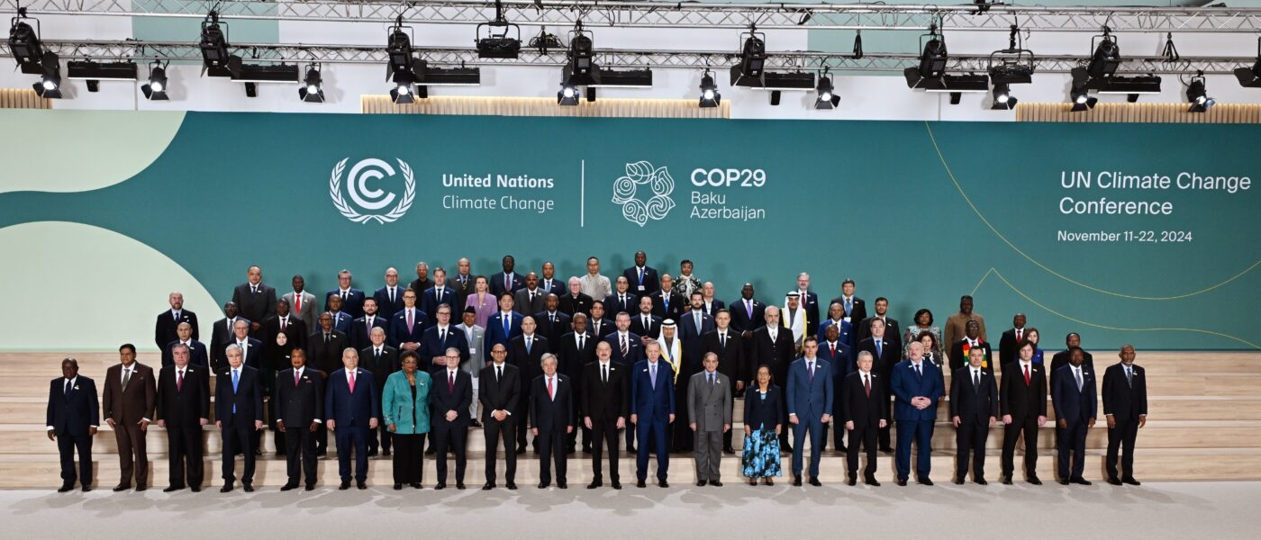 Global leaders stand in front of COP29 sign at the event.