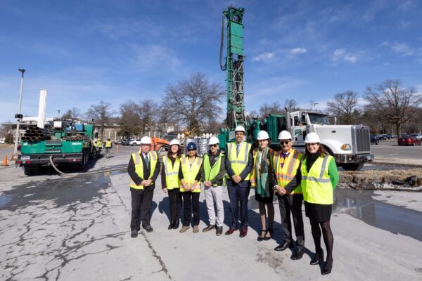University of Albany Decarbonization Project to Reduce Fossil Fuel Consumption Construction works, both men and women, dressed in bright vests, stand at a worksite.